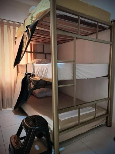 a bunk bed in a room with a chair at Multiverse Hostel in Medellín
