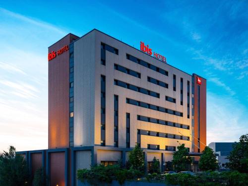a building with a red hotel sign on it at ibis Ankara Airport Hotel in Ankara