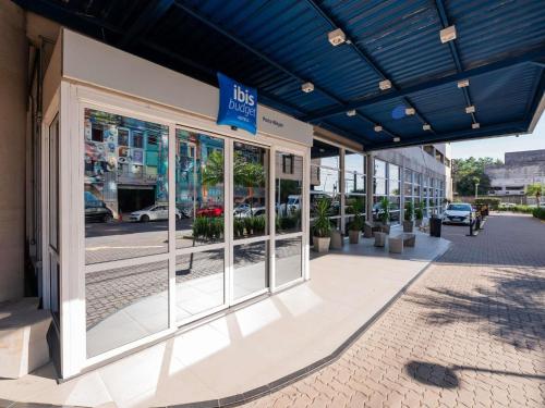 a store front with a blue awning on a street at ibis budget Porto Alegre - Super Econômico in Porto Alegre
