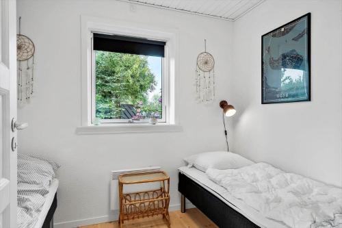 a bedroom with a bed and a window at 7032-Bogo-Kvaernen-32 in Gammelby