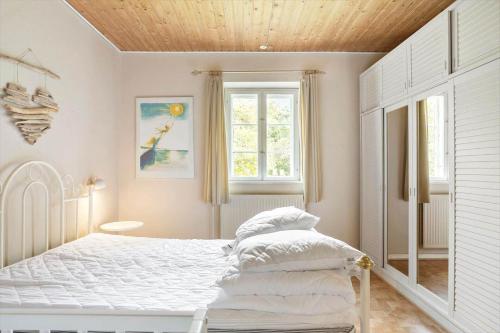 a bedroom with a white bed and a window at 4302-Stege-Nordfeldvej-48-B in Stege