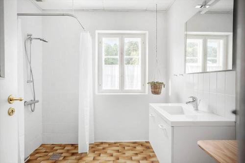 a white bathroom with a shower and a sink at 4302-Stege-Nordfeldvej-48-B in Stege