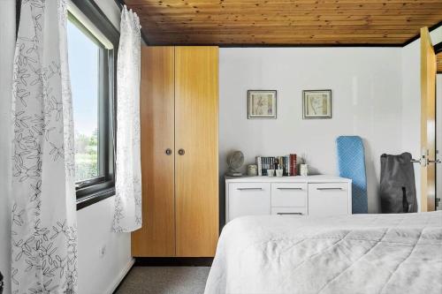 a bedroom with a bed and a window at 7041-Bogo-By-Tarnbakken-21 in Bogø By