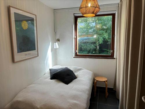 a small room with a bed and a window at 2007-Stege-Aedelgranen-3 in Stege