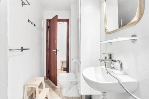 a white bathroom with a sink and a toilet at 2007-Stege-Aedelgranen-3 in Stege