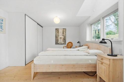 a white bedroom with two beds and a table at R623-Rodvig-Laurasvej-13 in Rødvig
