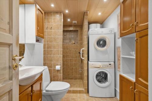 a bathroom with a toilet and a washing machine at R623-Rodvig-Laurasvej-13 in Rødvig