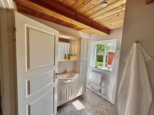 a bathroom with a sink and a toilet and a window at 6040-Stege-Rytsebaekvej-39 in Stege