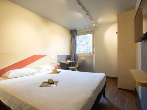 a hotel room with a bed with a book on it at ibis budget Avignon Centre in Avignon
