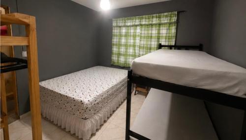two bunk beds in a room with a window at kit net central 1 in Serra Negra