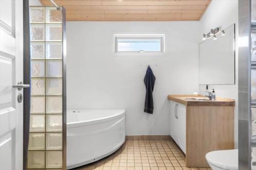 a bathroom with a tub and a toilet and a sink at HA364-Hals-Hou-Mose-19 in Hals