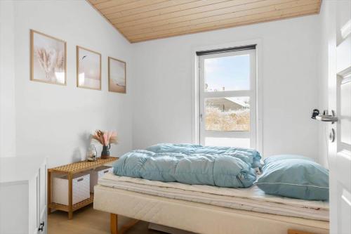 a bed sitting on a bench in a room with a window at HA364-Hals-Hou-Mose-19 in Hals