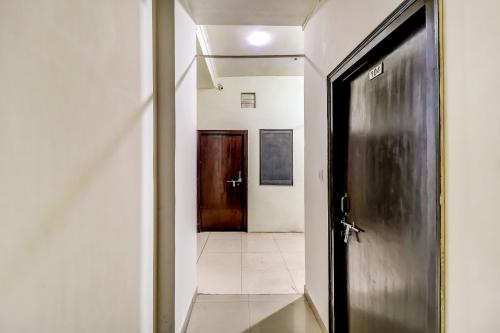 a door leading to a hallway with a hallwayngth at Hotel O by OYO Dhruv Inn in Izatnagar