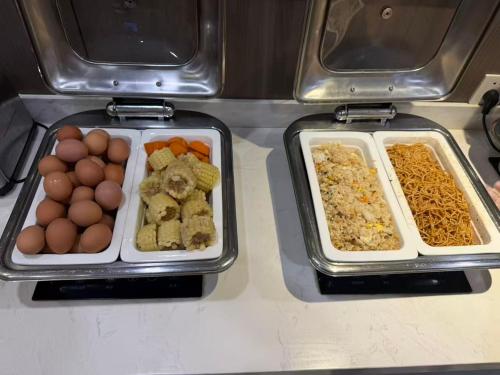 two trays of food sitting on top of a counter at Hanting Hotel Shanghai Wujiaochang in Shanghai