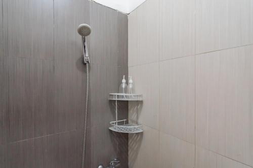 a shower with a shower head in a bathroom at RedDoorz @ Galuh Mas in Karawang