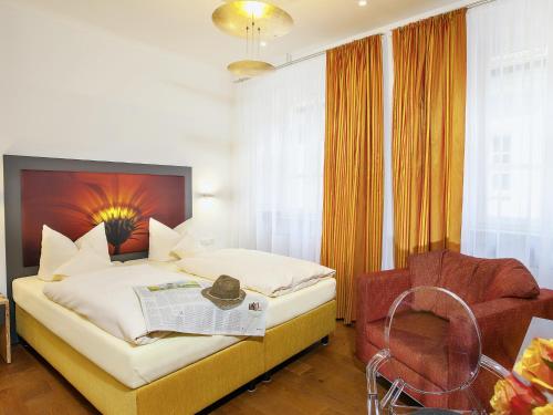 a hotel room with a bed and a chair at Hotel Münchner Hof und Blauer Turm in Regensburg