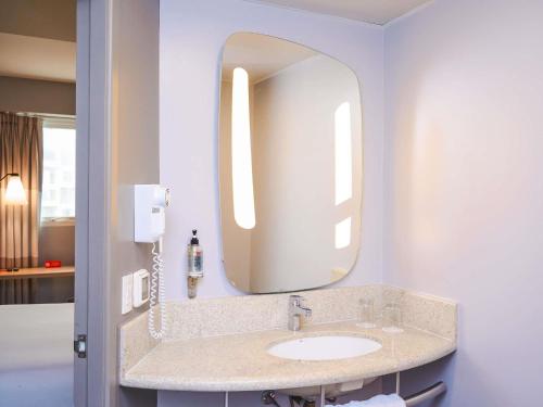 a bathroom with a sink and a mirror at ibis Lima Reducto Miraflores in Lima