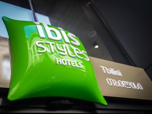 a sign for a store with a green and white sign at ibis Styles Tbilisi Center in Tbilisi City