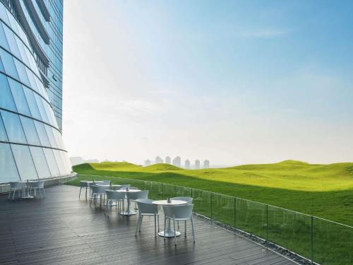 a row of tables and chairs on a balcony of a building at Sofitel Foshan Shunde in Shunde