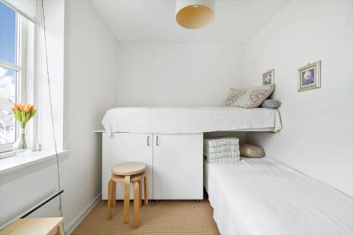 a bedroom with two bunk beds and a stool at 4170-Borre-Klintholm-Havneby-70 in Borre