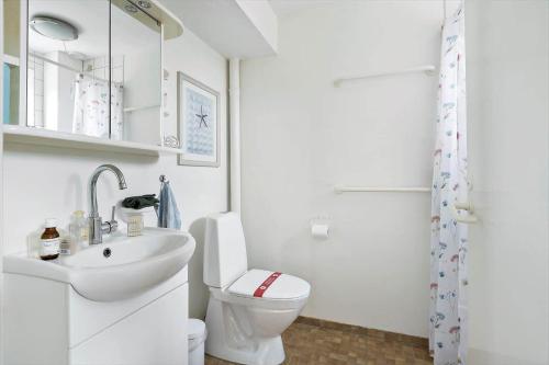 a white bathroom with a toilet and a sink at 4170-Borre-Klintholm-Havneby-70 in Borre