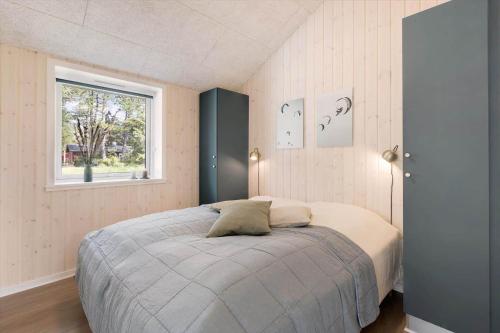 a bedroom with a large bed with a window at 0333-Romo-Lyngvejen-12 in Høm