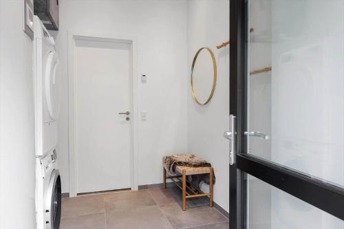a hallway with a mirror and a chair next to a door at 0333-Romo-Lyngvejen-12 in Høm