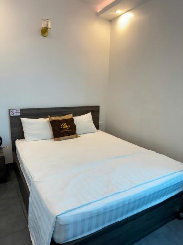 a bedroom with a large bed with white sheets at Hoàng Long Hotel 