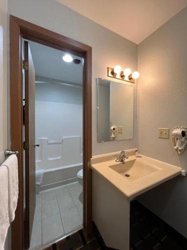 a bathroom with a sink and a shower at Deluxe Inn Hotel in Nebraska City in Nebraska City