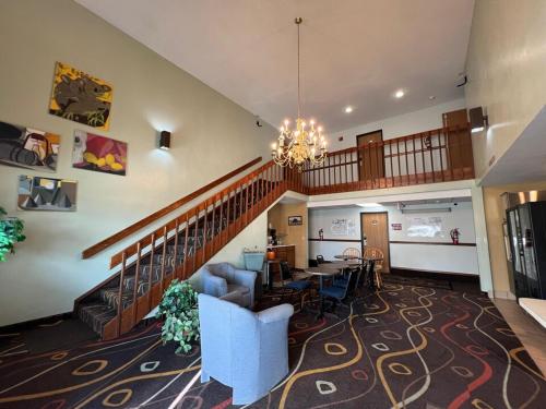 a living room with a staircase and a dining room at Deluxe Inn Hotel in Nebraska City in Nebraska City