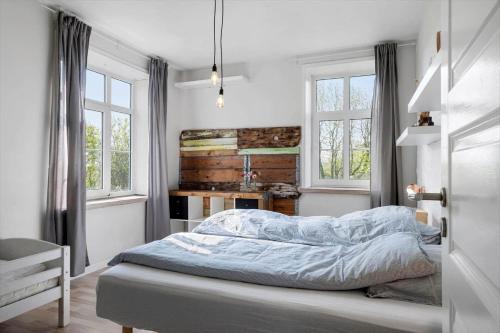 a bedroom with a bed and two windows at 0057-Romo-Juvrevej-49 in Høm