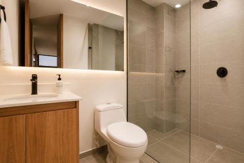a bathroom with a shower and a toilet and a sink at Metropolitan Living by HOUSY in Medellín