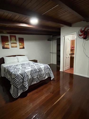 a bedroom with a bed and a wooden floor at MY HOUSE IN MACAS, SUITE AMOBLADA in Macas