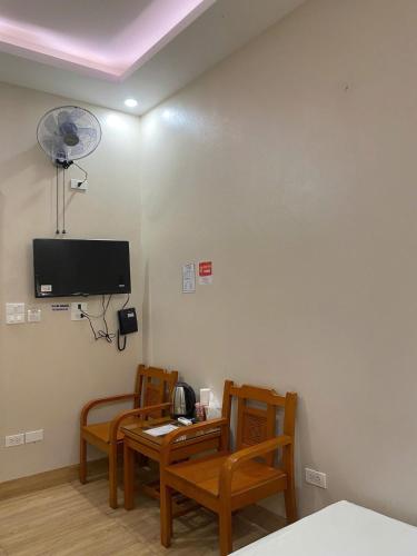 a room with two chairs and a table and a tv at Hoàng Long 2 Hotel in Chúc Sơn