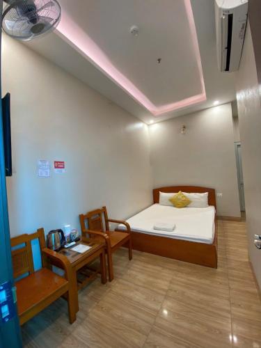 a bedroom with a bed and two chairs and a table at Hoàng Long 2 Hotel in Chúc Sơn