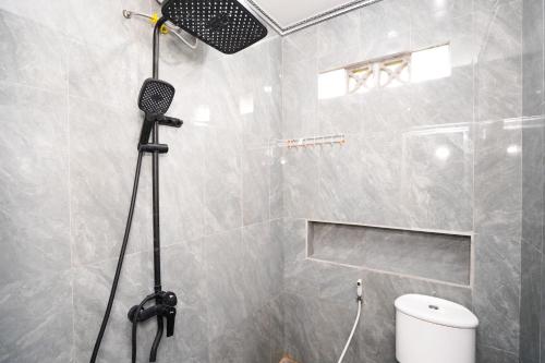 a bathroom with a shower with a toilet and a camera at The Lavana Astungkara in Beran-kidul