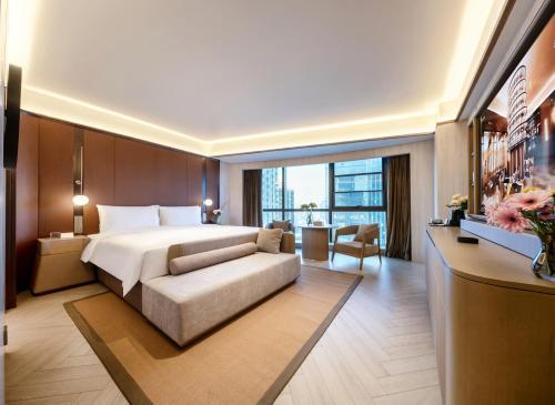 a hotel room with a bed and a couch at Orange Crystal Hotel Kunming Wanda Plaza in Kunming