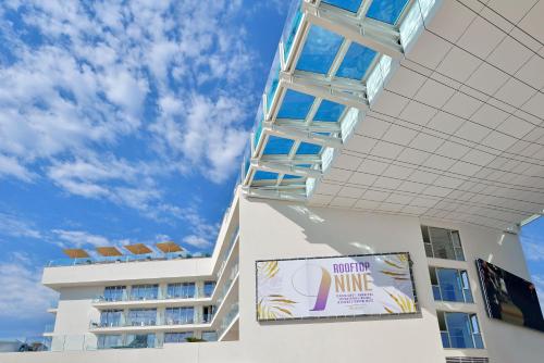 a white building with a sign in front of it at INNSiDE by Meliá Calviá Beach in Magaluf