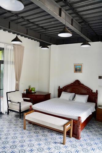 a bedroom with a bed and a bench in it at Laman Riverside in Nguyên Ngoại