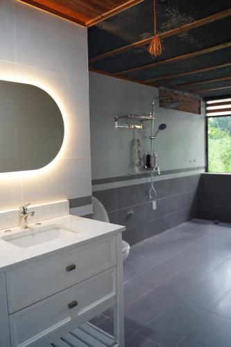 a bathroom with a white sink and a mirror at Laman Riverside in Nguyên Ngoại