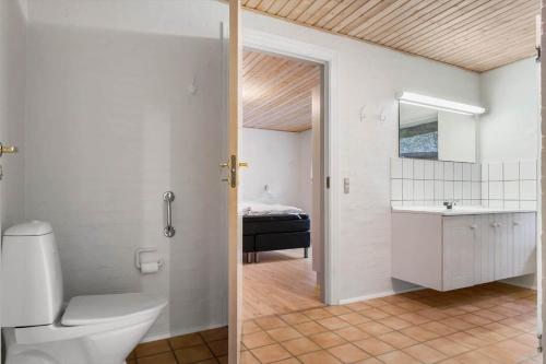 a bathroom with a toilet and a sink and a bedroom at 2503-Romo-Hattesvej-38 in Høm