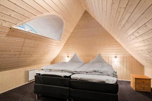a bedroom with a large bed in a wooden ceiling at 2503-Romo-Hattesvej-38 in Høm