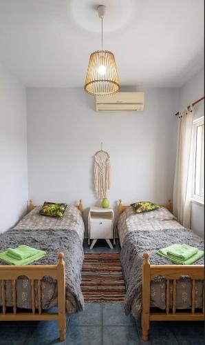 a bedroom with two beds and a chandelier at Home Talampaya in Villa Unión