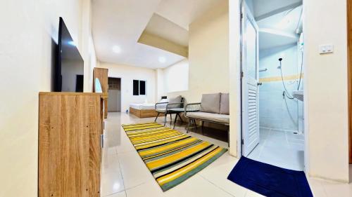 a living room with a couch and a shower at Vista Residence Patong in Patong Beach