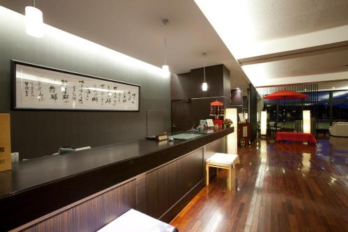 un restaurante con una barra larga y un bar en Ryokan Biyunoyado, en Yamanouchi