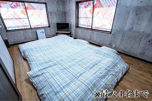 a bedroom with a bed in a room with two windows at STEP by STEP - Vacation STAY 25751v in Kanayama
