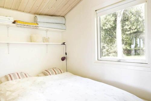 a bedroom with a bed and a window at 15524-Farevejle-Lynghoj-5 in Fårevejle