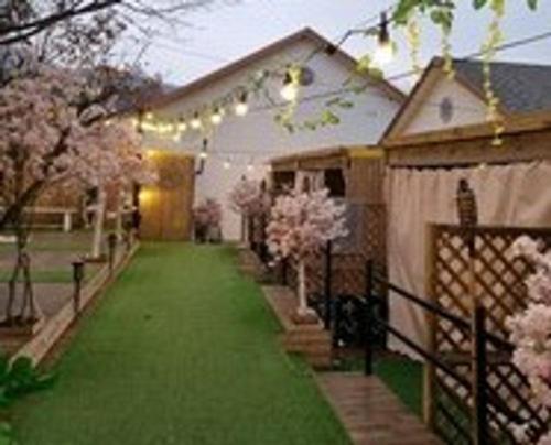 a house with a fence and a yard with flowering trees at Pocheon Yolafongta Pension in Pocheon