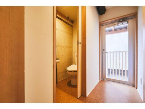 a bathroom with a toilet and a sliding door at Batonship - Vacation STAY 12907 in Osaka