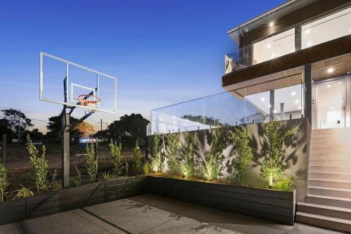 a house with a glass facade with a basketball hoop at Casa Lux in Aireys Inlet